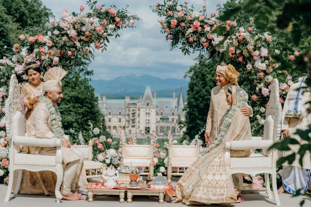 Couple under the floral mandap during the wedding ceremony